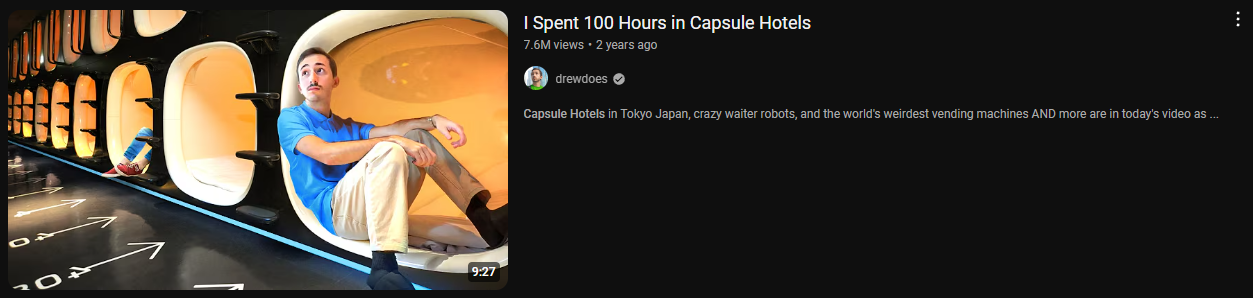 A YouTube video thumbnail with a dark background. On the left is a shot of a man sitting inside a capsule hotel room, looking surprised. The capsule is white with an orange interior. In the background, there are more capsule rooms lined up along a wall. There are white arrows painted on the floor pointing towards the capsules. On the right is the video title "I Spent 100 Hours in Capsule Hotels" in white letters, followed by the view count and upload date. Below is the channel name "drewdoes" with a verified checkmark and a brief description of the video content: "Capsule Hotels in Tokyo Japan, crazy waiter robots, and the world's weirdest vending machines AND more are in today's video as..." The video duration "9:27" is visible in the bottom right corner of the thumbnail.