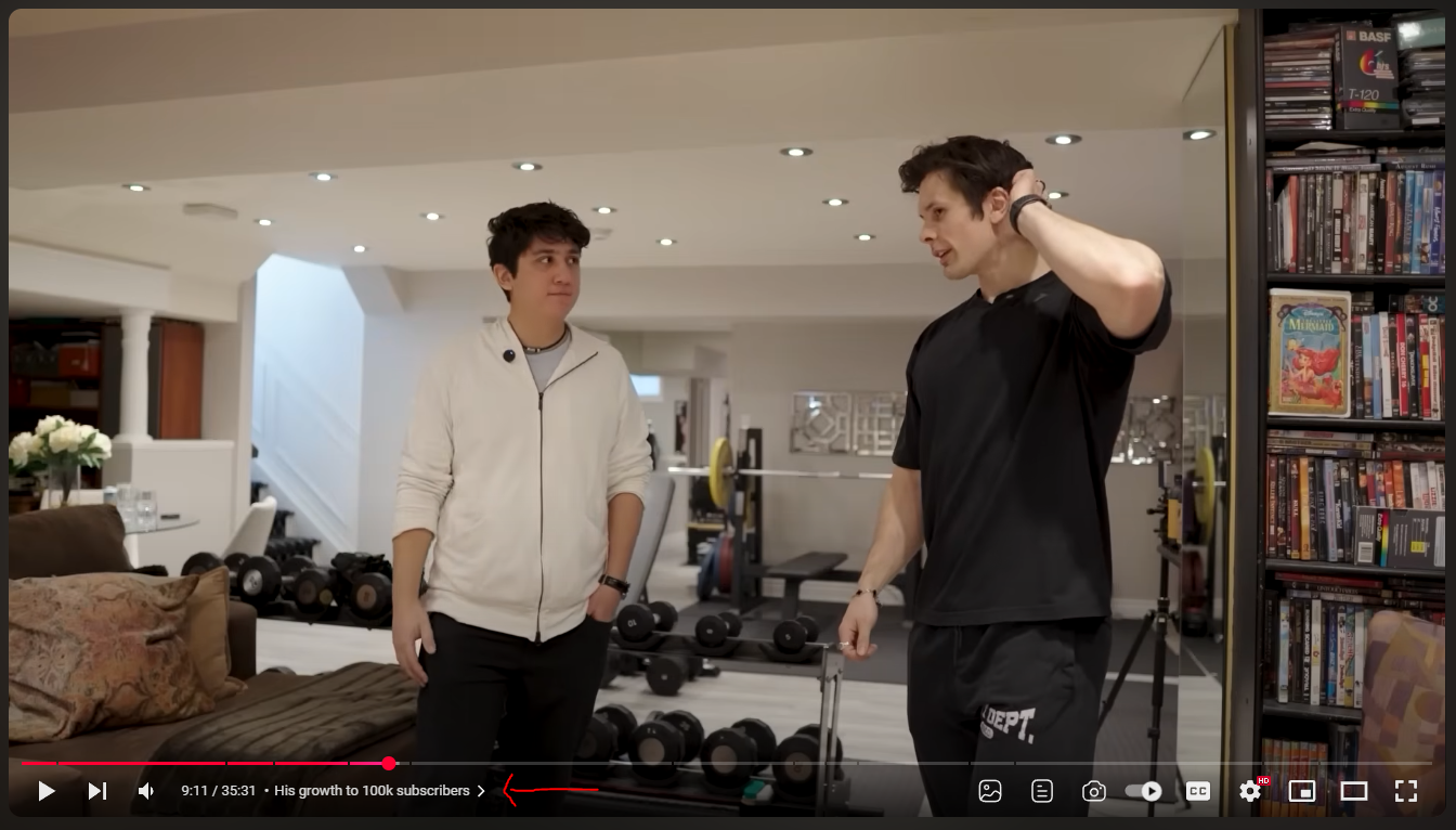 Two content creators talking in a home gym during a YouTube video segment titled “His growth to 100k subscribers,” with workout equipment and DVDs in the background.