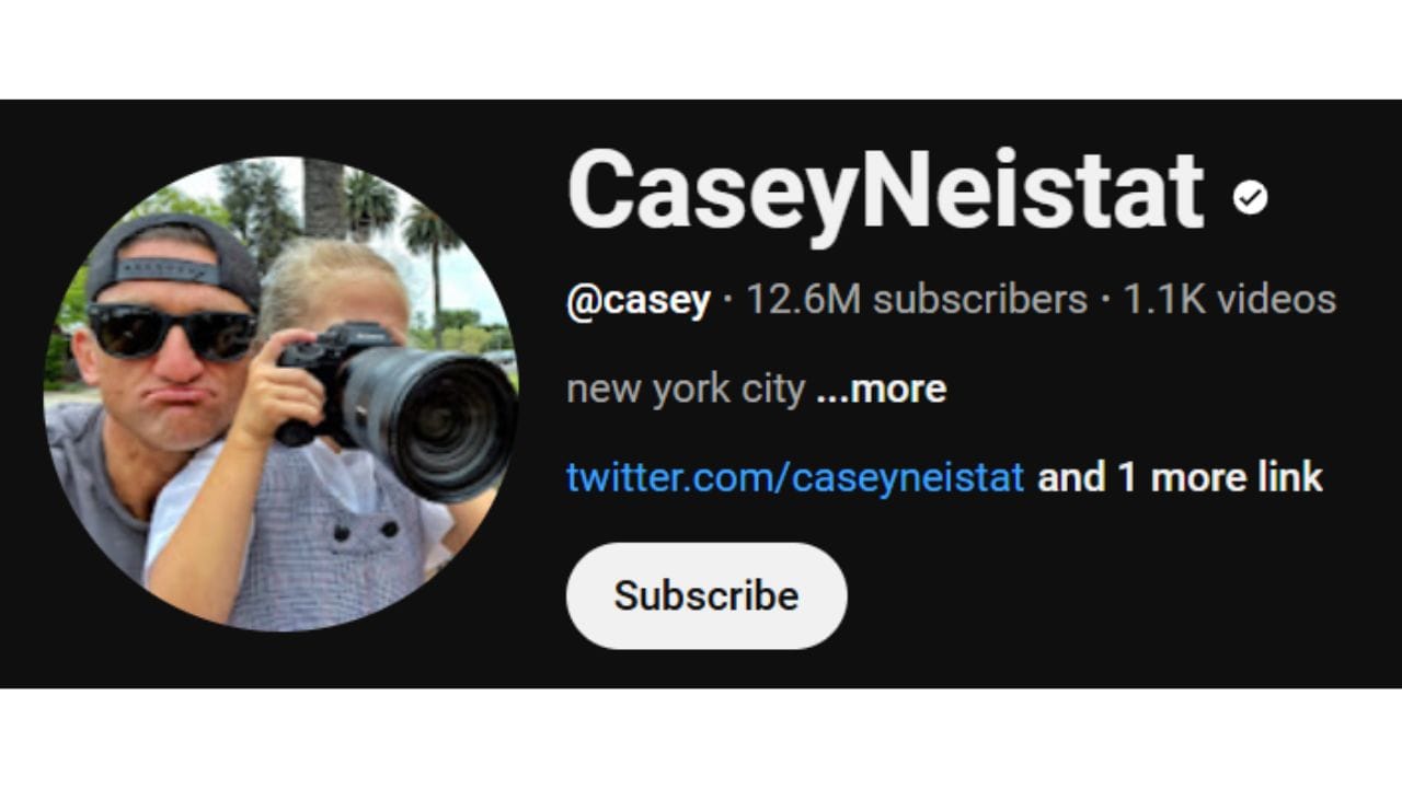 A dark-themed YouTube channel banner for Casey Neistat. The profile picture shows a close-up of Casey Neistat wearing sunglasses and holding a camera with another person partially visible. The channel name "CaseyNeistat" is in white letters, followed by a black dot. Below is the channel username "@casey", the subscriber count (12.6 million), and the video count (1.1K). The banner also includes the text "new york city ...more", a link to Casey Neistat's Twitter account, and a "Subscribe" button.