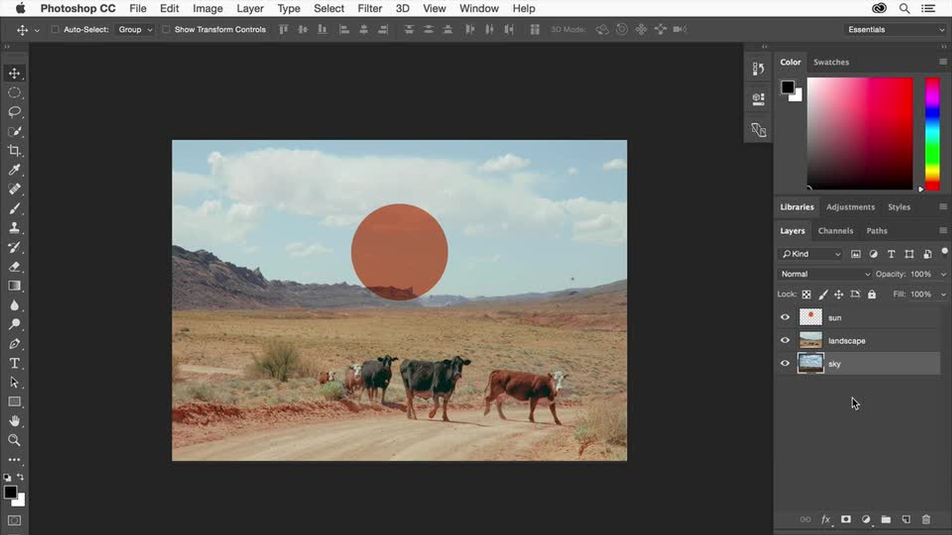 A screenshot of the Adobe Photoshop CC interface. In the center, an image of a desert landscape under a partly cloudy sky is being edited. The landscape features a dirt road running through dry, scrubby terrain with rocky hills in the background. Three cows are walking along the road. A large, semi-transparent orange circle is overlaid on the sky, partially obscuring the clouds. On the right side of the Photoshop window, the "Layers" panel is visible, showing three layers: "sun" (likely the orange circle), "landscape," and "sky" (the original background layer). The "sun" layer is currently selected. Other Photoshop panels such as "Color" and "Swatches" are also visible on the right. The top menu bar displays standard Photoshop options like "File," "Edit," "Image," "Layer," etc. The toolbar on the left provides various selection and editing tools. The overall view shows an image manipulation process where a circular element representing the sun is being added or adjusted within the landscape scene.