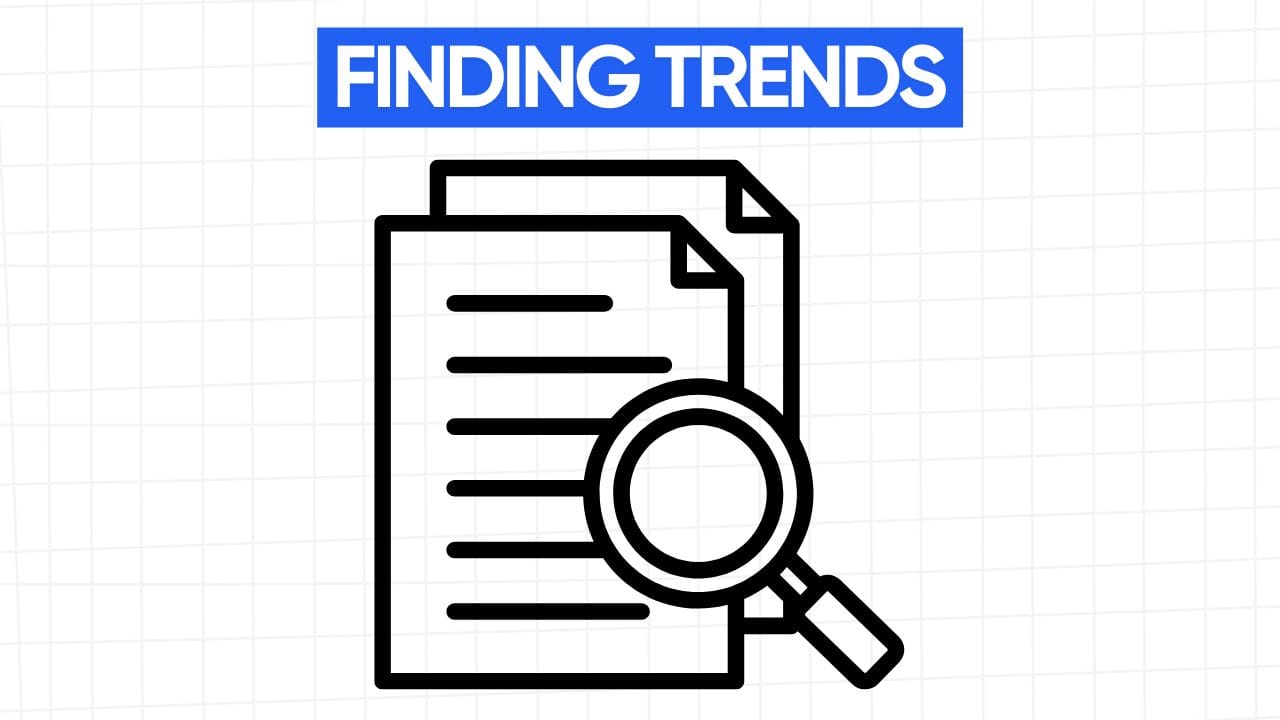 A white rectangular graphic with rounded corners and a light gray grid pattern in the background. At the top is a blue banner with the text "FINDING TRENDS" in white letters. Below the banner is a line art illustration of two stacked documents with horizontal lines representing text. A magnifying glass is positioned over the documents, symbolizing the act of searching and analyzing information. The image visually represents the process of identifying and analyzing trends through research and investigation.